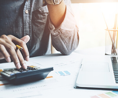 Close up a man working about financial with calculator at desk