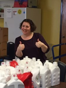Charla Roth, audit partner of Dannible & McKee, LLP giving thumbs up for an abundance of detergent for a charity