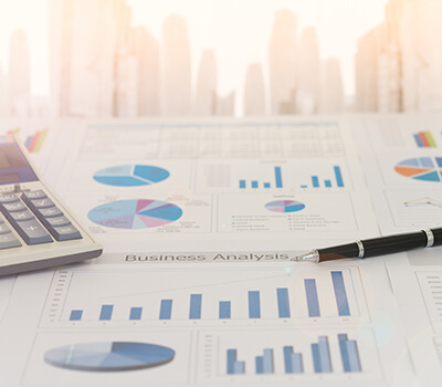 Pen on earnings report with calculator and pen analyze return on investment.