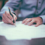 Man using a pen signing papers