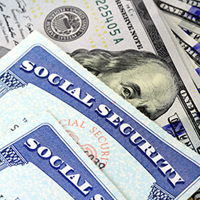 Cropped photo of two Social Security cards and 100 dollar bills representing benefits