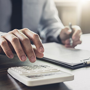 Businessman working in office, using calculator analysis finance document report business valuation