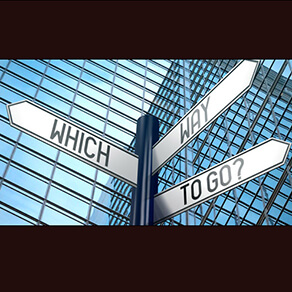 3- Way Street sign in front of building reading