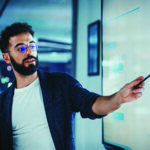 Man writing and pointing to something on a whiteboard