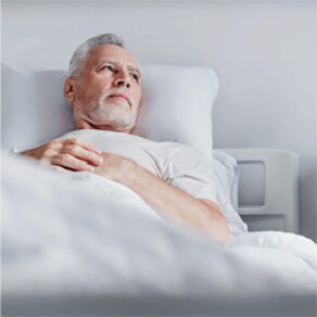 Man laying in bed with arms crossed