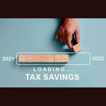 Hand lining up blocks in a row with the years 2021 and 2022 on either side with the words loading tax savings" under it