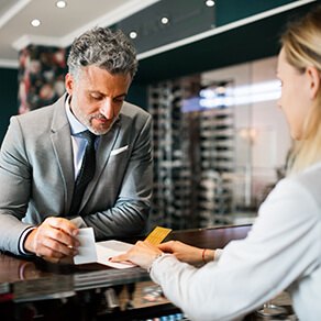 Mature businessman checking in at hotel reception.