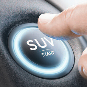 Lit up "SUV" button inside a vehicle with person's finger extended ready to push it