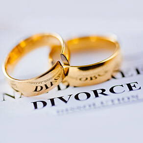 Two wedding rings interlocked laying over the words 