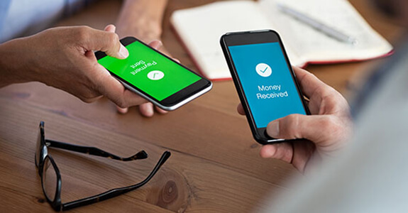 Closeup hands holding mobile phone with application for send and receive money. Man and woman holding smartphone and making payment transaction. Smart phone screen displaying payment sent and money received message after transaction.