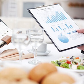 Close-up of open notepad and business document in male hands during business lunch