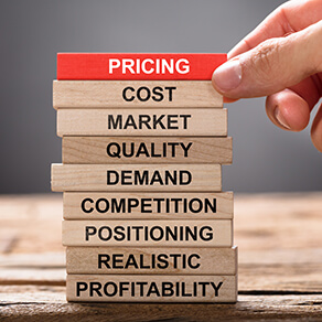 Closeup of hand building pricing concept with wooden blocks on wood