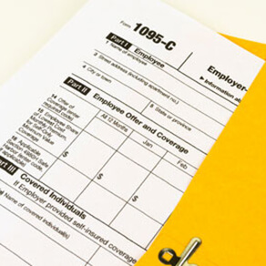 Tax forms coming out of a yellow business envelope