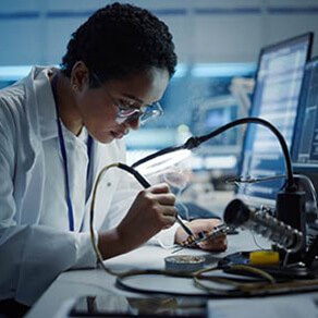 Modern Electronics Research, Development Facility: Black Female Engineer Does Computer Motherboard Soldering. Scientists Design PCB, Silicon Microchips, Semiconductors. Medium Close-up Shot