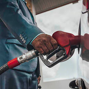 Business man refuelling his modern car at petrol station