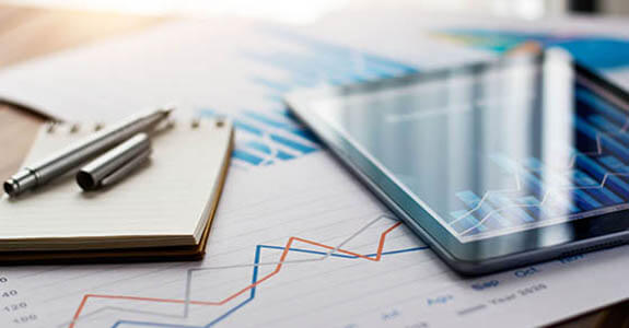 Business document report on paper and tablet with sales data and financial business growth graph on table background.