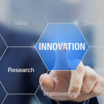 Touch screen of honeycomb images with person touching the word innovation