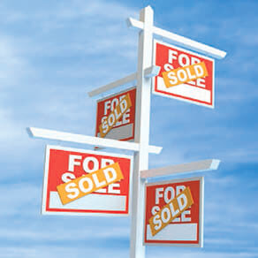 Photo provides four “For Sale” signs outdoors that are connected to each other and covered by the word “Sold,” indicating something—whether it be property or something one can hold—was sold.