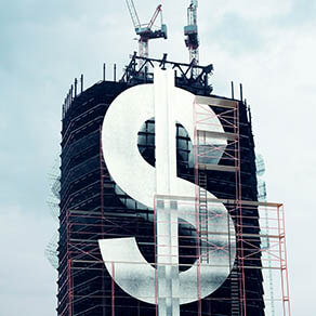 Building under construction with a large dollar sign on the side