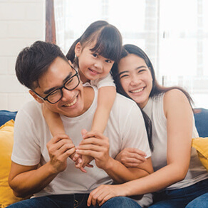 Family of three sitting together smiling