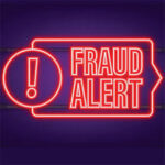 Neon pink sign reading "Fraud Alert"