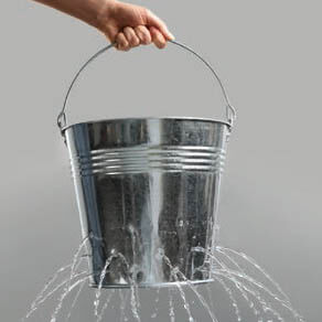 Hand holding bucket of water with multiple leaks