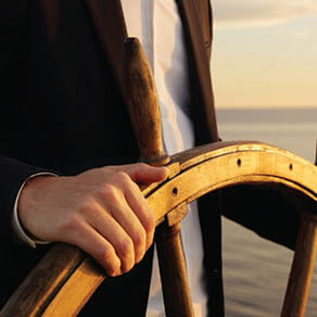 Hand on of someone steering a ship
