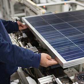 Production of solar panels, man working in factory.