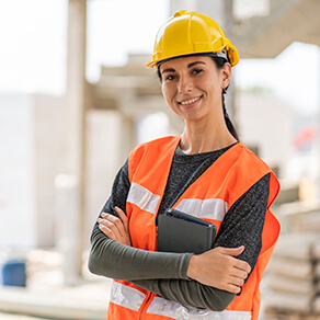 A woman construction worker standing with her arms crossed
