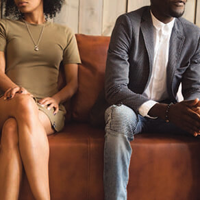 Couple sitting on a couch sitting spaced apart