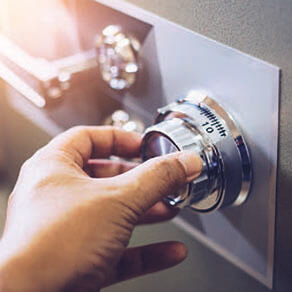 Hand turning dial on a safety deposit box