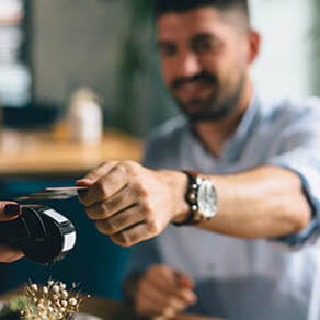 man making payment with smartphone in restaurant