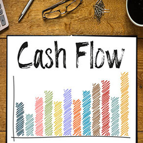 Drawing of a colorful bar graph with the words "cash flow" above it on a desk