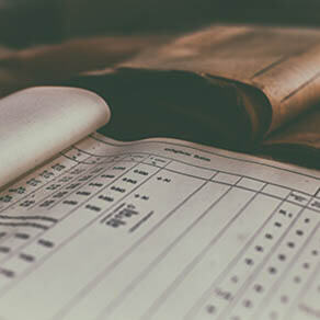 Open financial book next to leather bound book