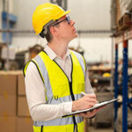 Warehouse staff working at warehouse taking notes on clipboard