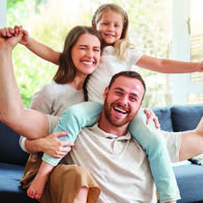 Family photo of husband, wife and daughter smiling and posing for the camera