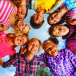 Group of childeren standing in a circle looking in together