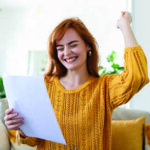 Young woman giving an excited reaction looking at a document