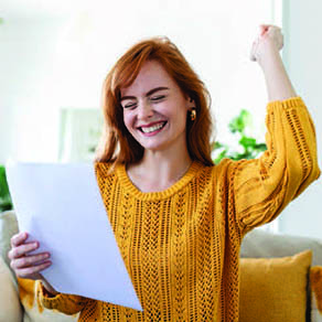 Young woman giving an excited reaction looking at a document