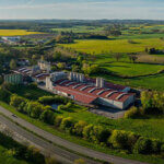 Industrial facility with red roofs, numerous tanks and silos