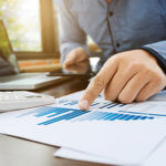 Person reviewing financial graph documents