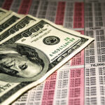 Hundred dollar bills laying on top of paper with numbers