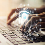 Hands typing on keyboard with cyber security protection lock symbol