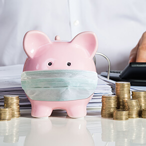 Piggy bank wearing mask with stacks of coins next to it and open binder with papers behind