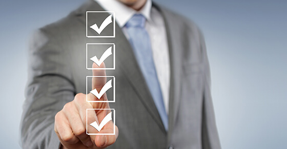 Man in business suit pointing at checkmarks in a list