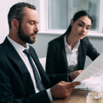 Professional Man and Woman sitting at a table reviewing a document