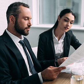 Professional Man and Woman sitting at a table reviewing a document