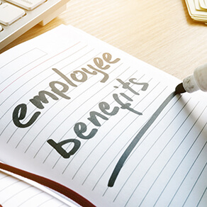 Hand is writing Employee benefits in a note.