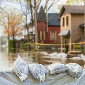 lose shot of flood Protection Sandbags with flooded homes in the background