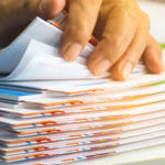 Stack of paper with colored tabs and hand flipping through them